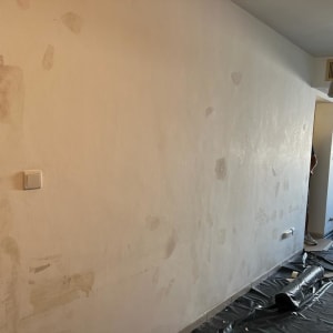 קיר צבוע חלקית עם יריעות פלסטיק על הרצפה