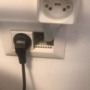 שקע חשמל עם תקע מחובר וקופסת חיבורים פתוחה