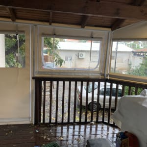 סוככים עם חלונות פלסטיק שקופים על מרפסת עץ