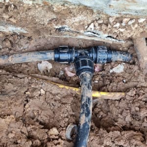 צינור פלסטיק שחור עם מחברים באדמה חשופה