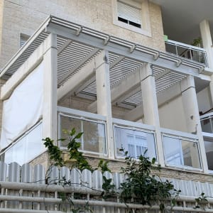 מרפסת עם גדר עץ וצמחייה מטפסת