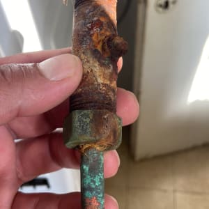 צינור חלוד עם חיבורי מתכת, מוחזק ביד