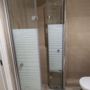 מקלחון זכוכית עם דלתות ומקלחת גשם