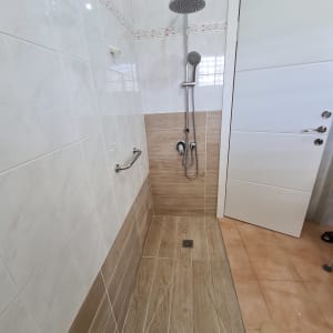 מקלחת חדשה עם אריחים וכלים סניטריים מותקנים