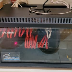 ארון תקשורת עם כבלים אדומים ומתג VisionNet