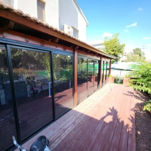 חלונות אלומיניום גדולים במרפסת עץ