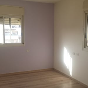 קיר צבוע בצבע סגול בהיר ליד חלון