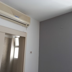 קיר צבוע בצבע אפור בהיר ליד מזגן