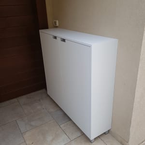 ארון לבן עם דלתות סגורות על רצפת אריחים