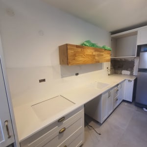 משטח שיש לבן במטבח עם ארונות עץ