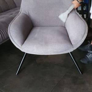 אדם מנקה כורסה עם שואב אבק