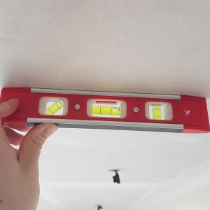 פלס מים אדום מוחזק על תקרה לבנה