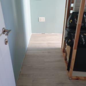 רצפת עץ חדשה, קיר צבוע, מדף עם חומרים