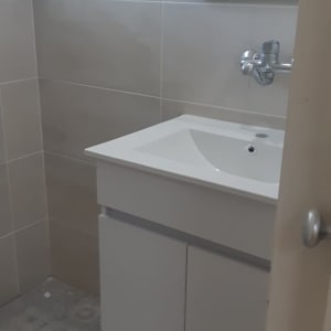 כיור חדש בחדר אמבטיה עם אריחים אפורים