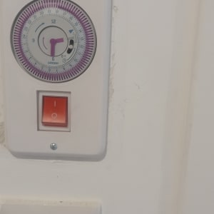 שעון טיימר חשמלי ומתג הפעלה על קיר