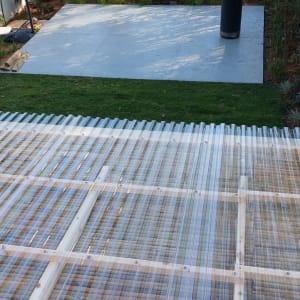 גג פלסטיק שקוף עם קורות עץ בגינה