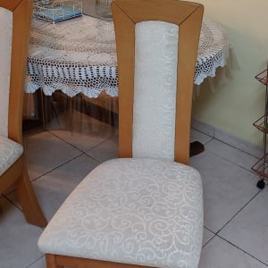 כיסא עץ עם ריפוד בד בהיר ודוגמה מעוטרת