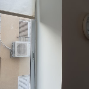 קיר צבוע מחדש ליד חלון עם תריס גלילה