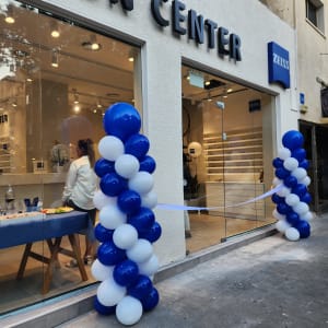 עמודי בלונים כחולים ולבנים בכניסה לחנות