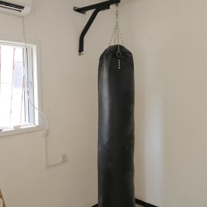 שק אגרוף תלוי על מתקן קיר בחדר