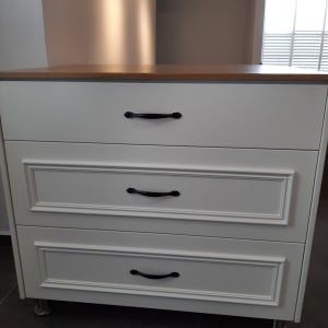 ארון מטבח לבן עם ידיות שחורות ומשטח עץ