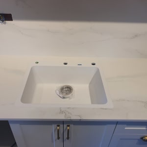 שיש לבן עם כיור מובנה וברזים מותקנים