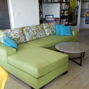 ספה ירוקה עם כריות צבעוניות בסלון
