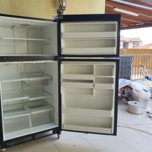 מקרר פתוח עם מדפים ריקים ומגירות