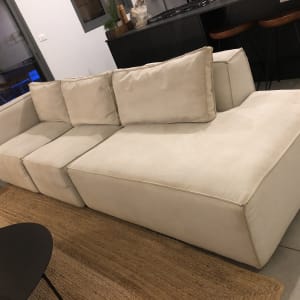 ספה בהירה עם כריות על שטיח