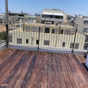 רצפת עץ על גג עם מעקה מתכת