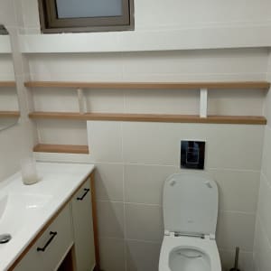 מדפים מעץ מותקנים על קיר בחדר אמבטיה