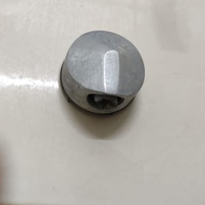 חלק מתכת עגול על קיר אריחים