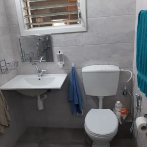 חדר שירותים משופץ עם חיפוי קיר, אסלה וכיור תלוי
