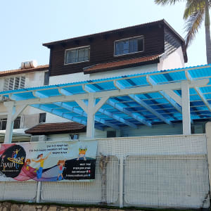 פרגולה עם גג פלסטיק כחול בחצר בית