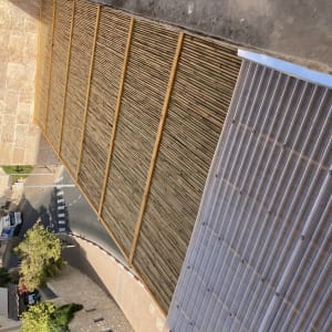 גדר במבוק על גג ליד קיר אבן