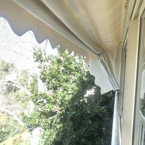 סוכך בד לבן עם קצוות גליים על מרפסת