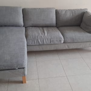 ספה אפורה עם רגלי עץ על רצפת אריחים