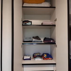 ארון בגדים פתוח עם מדפים מסודרים בבגדים מקופלים