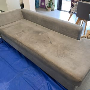 ספה אפורה עם כתמים על יריעת פלסטיק כחולה