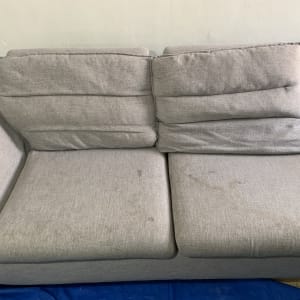 ספה אפורה עם כתמים על המושב והמשענת