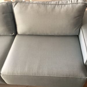 ספה אפורה נקייה עם כריות ישיבה ומשענת