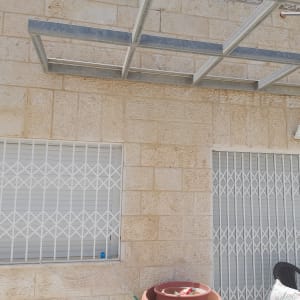 שני פנסי תאורה מותקנים על קיר אבן חיצוני