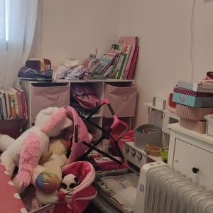 חדר עם צעצועים, ספרים וארגזי אחסון ורודים