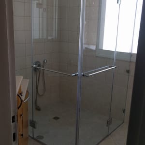 מקלחון זכוכית עם דלתות ומקלחת יד