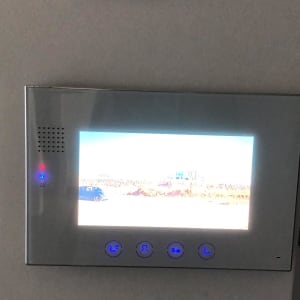 מסך אינטרקום עם כפתורים מוארים בכחול