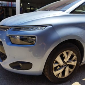 חזית רכב כחול עם פנס קדמי וגלגל