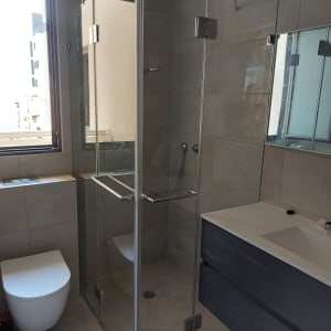 מקלחון זכוכית עם דלתות פתוחות וברז מקלחת