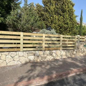 גדר עץ על קיר אבן בגינה