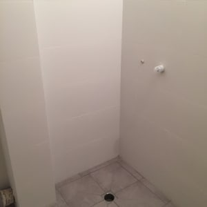 חדר אמבטיה עם אריחים חדשים וניקוז ברצפה