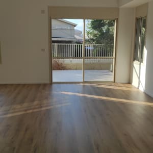 חדר ריק עם רצפת עץ נקייה ואור שמש